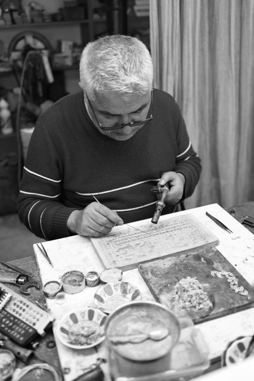 Free A meticulous craftsman embosses intricate designs onto jewelry in an artisan workshop. Stock Photo