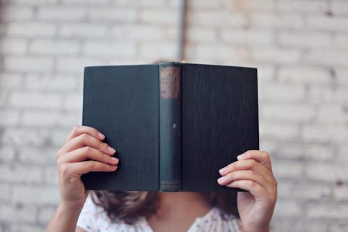 Free Selective Focus Photography of Woman Holding Book Stock Photo