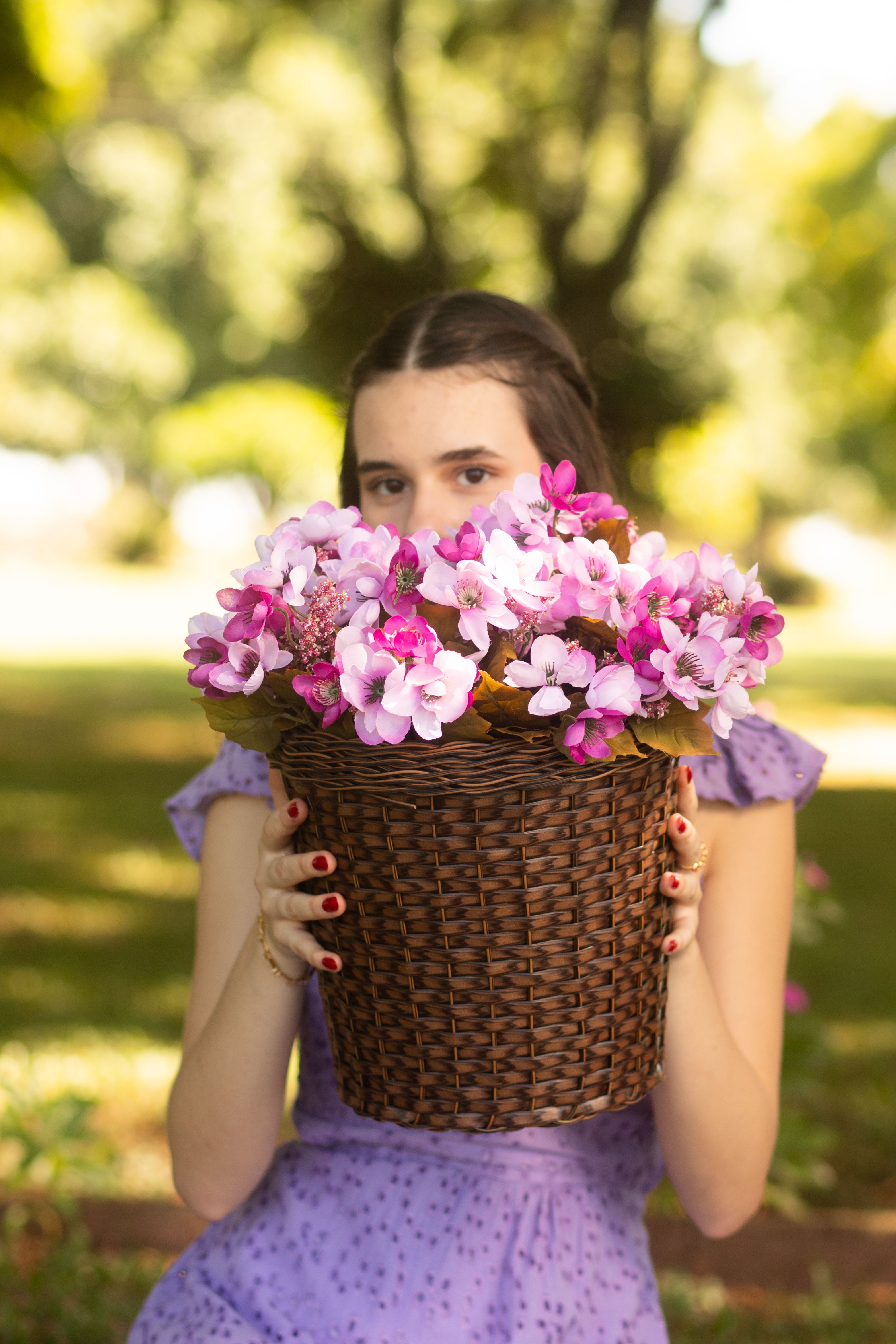 [ColoSach]-young-woman-in-a-garden-holding-a-woven-basket-full-of-pink-and-purple-flowers.