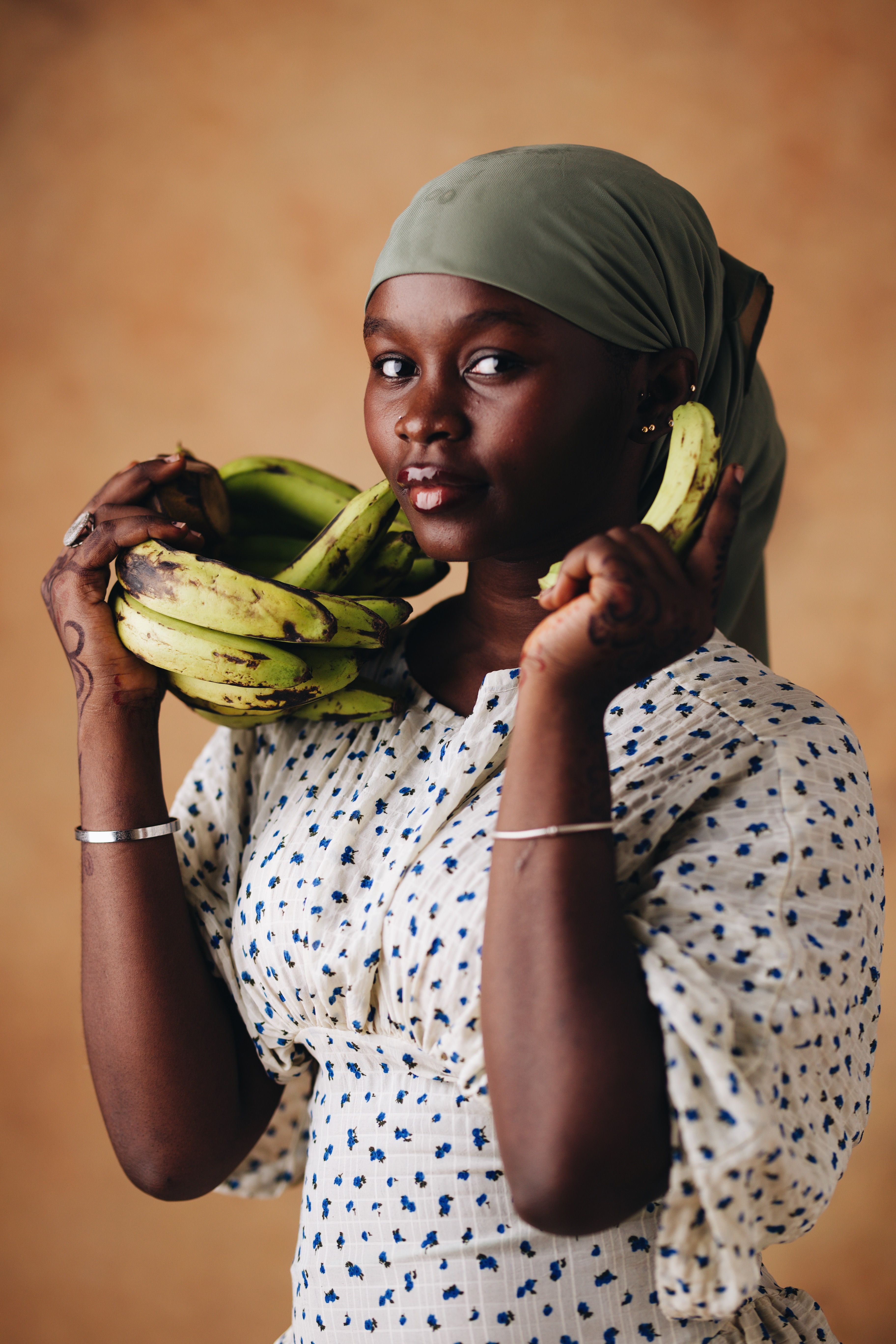 Charming portrait of a woman with plantains, showcasing traditional attire and a warm, earthy aesthetic.