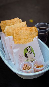 Delicious crispy pastel served with caldinho and a refreshing soda in Campinas, Brazil.