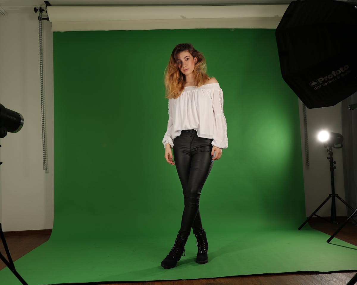 A frothy hot matcha latte in a clear glass mug on a wooden board