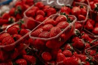 西班牙市场上，塑料容器中新鲜草莓的特写，多汁且色泽鲜红