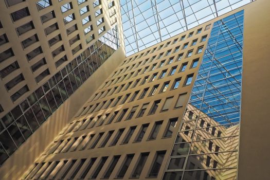 A striking view of a modern glass atrium with reflections and geometric patterns.