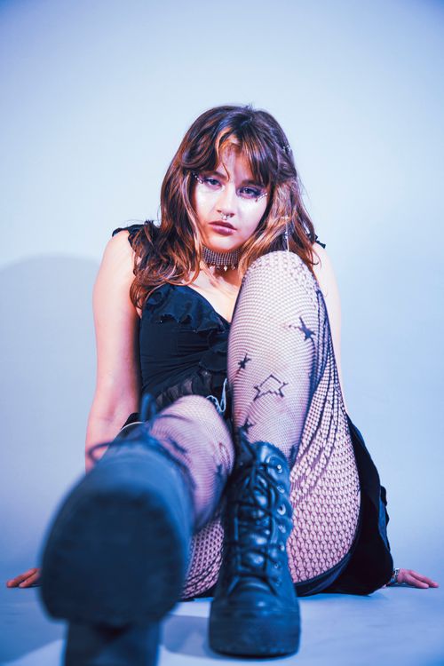 Free Portrait of a woman in edgy fashion with colorful lighting highlighting unique style. Stock Photo