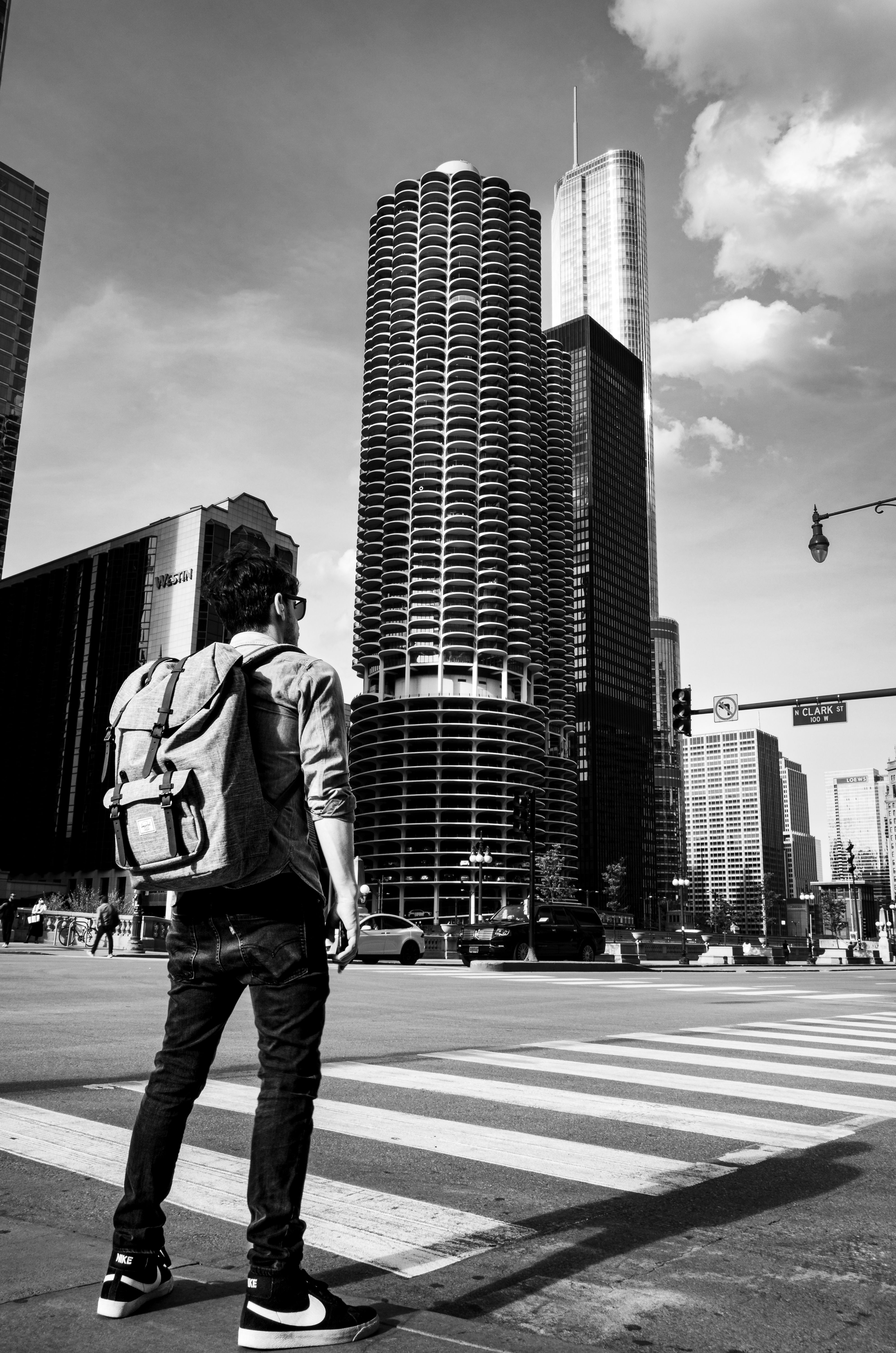 Black and white photo of a young traveler in downtown Chicago with skyscrapers.
