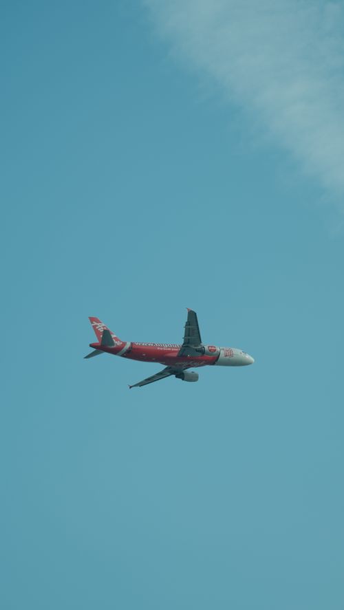 Free A commercial airplane soars through a vibrant blue sky, an icon of travel and technology. Stock Photo