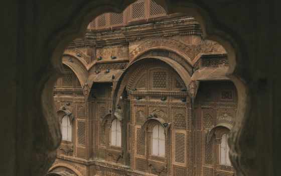 View through intricate arches at the captivating Mehrangarh Fort in Jodhpur, showcasing detailed latticework.