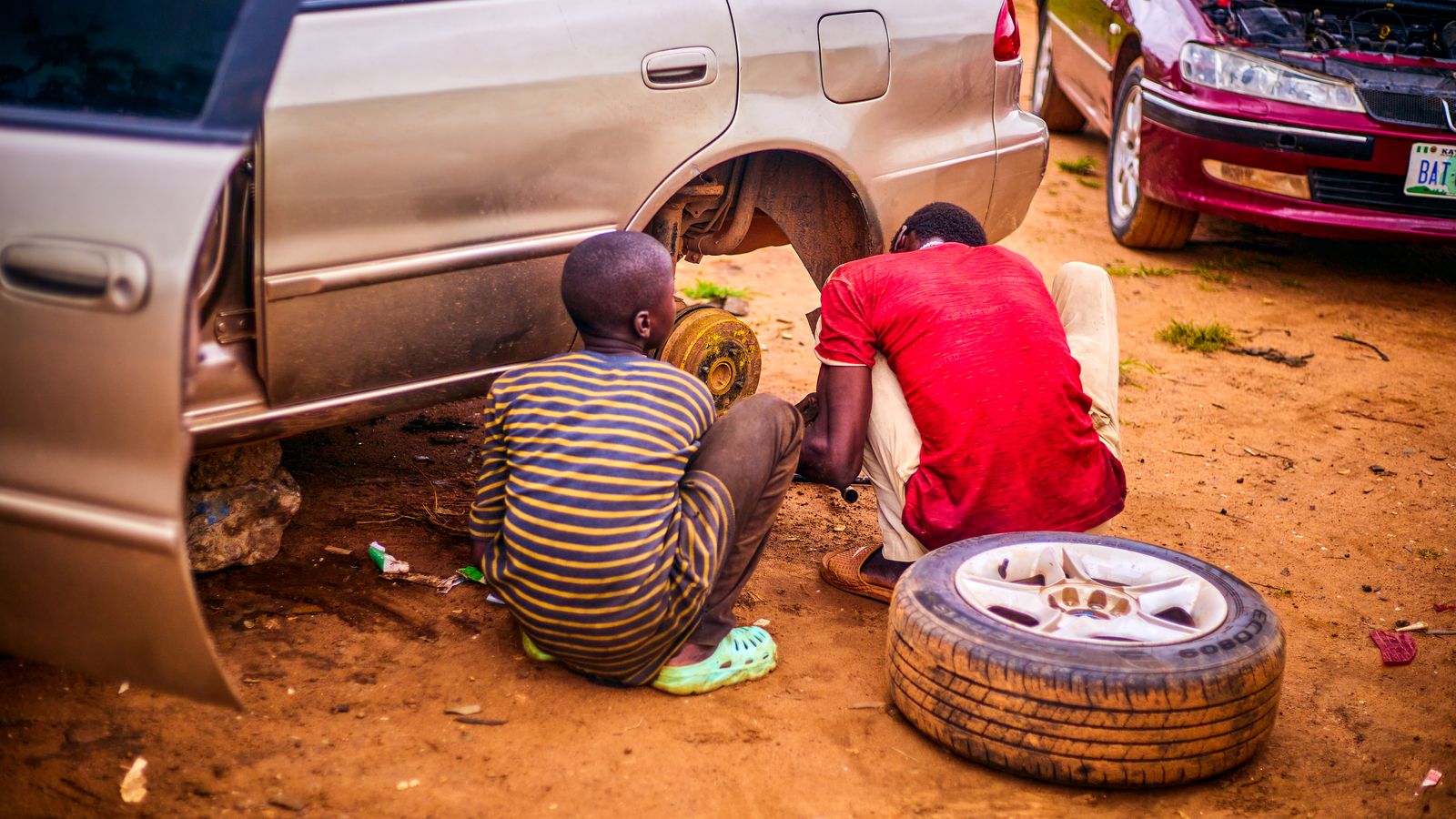 Mechanics repairing car on a dirt road in nigeria, Central African Republic
