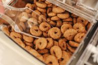 散装容器中各种烤饼干的特写视图，用勺子舀取