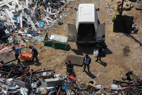 Free Aerial perspective of workers amid a bustling junkyard with a parked van in Baku, Azerbaijan. Stock Photo