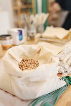 Canvas sack filled with chickpeas on a wooden counter, promoting zero waste shopping.