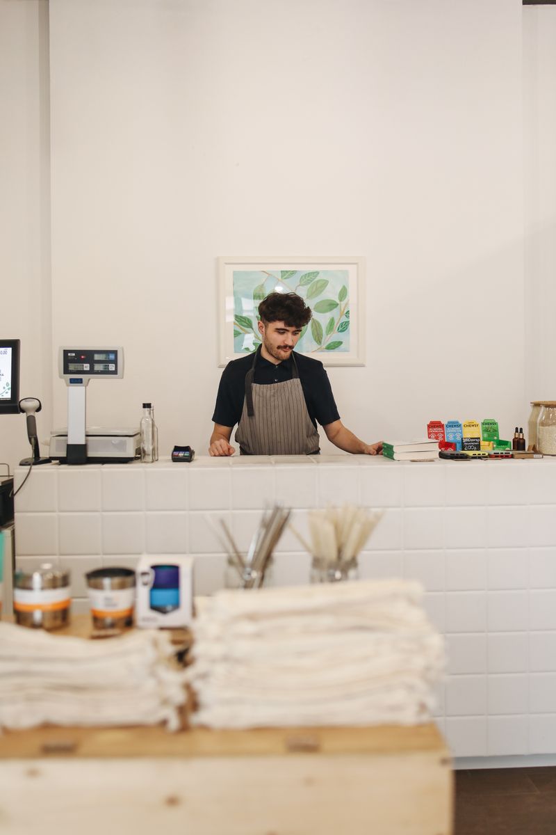 A cashier at the counter of a shop selling goods without packaging
