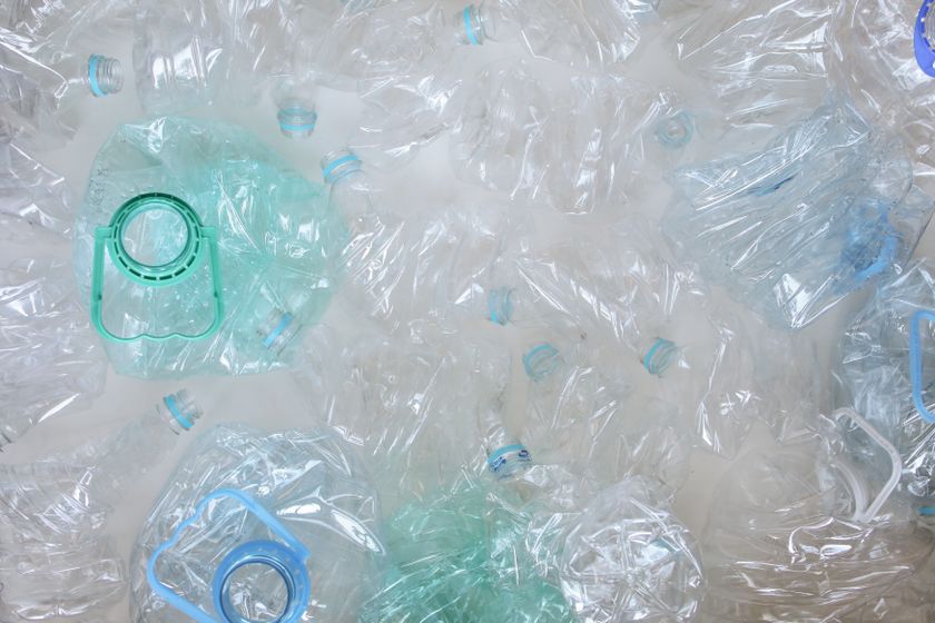 Overhead close-up of crushed clear plastic bottles collected for recycling, filling the frame.