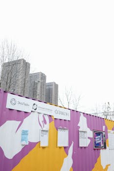 城市摩天大楼的背景下，一个五颜六色的回收中心容器正促进着环保倡议