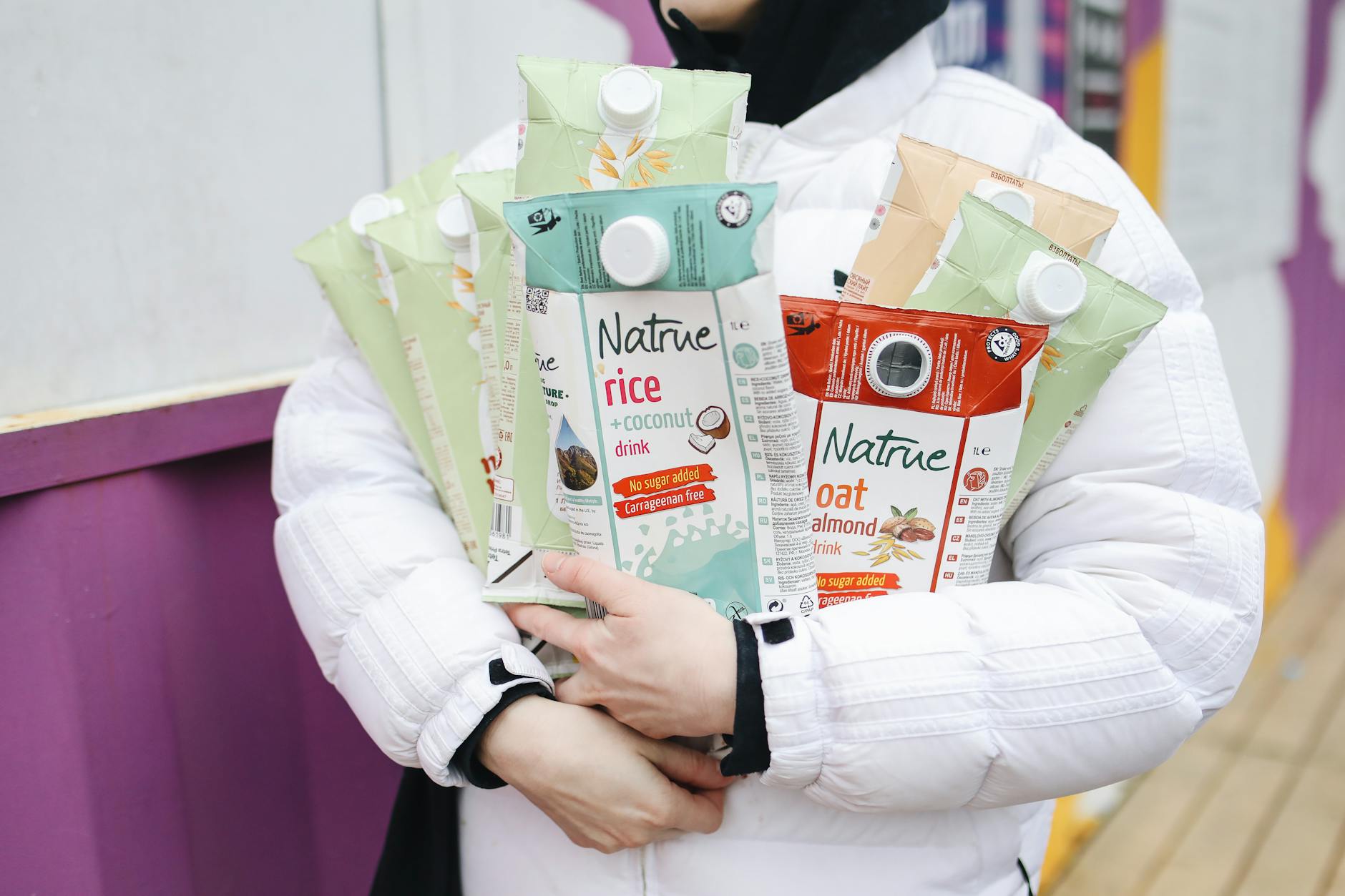 Eco-conscious individual holding various plant-based drink cartons for a sustainable lifestyle.