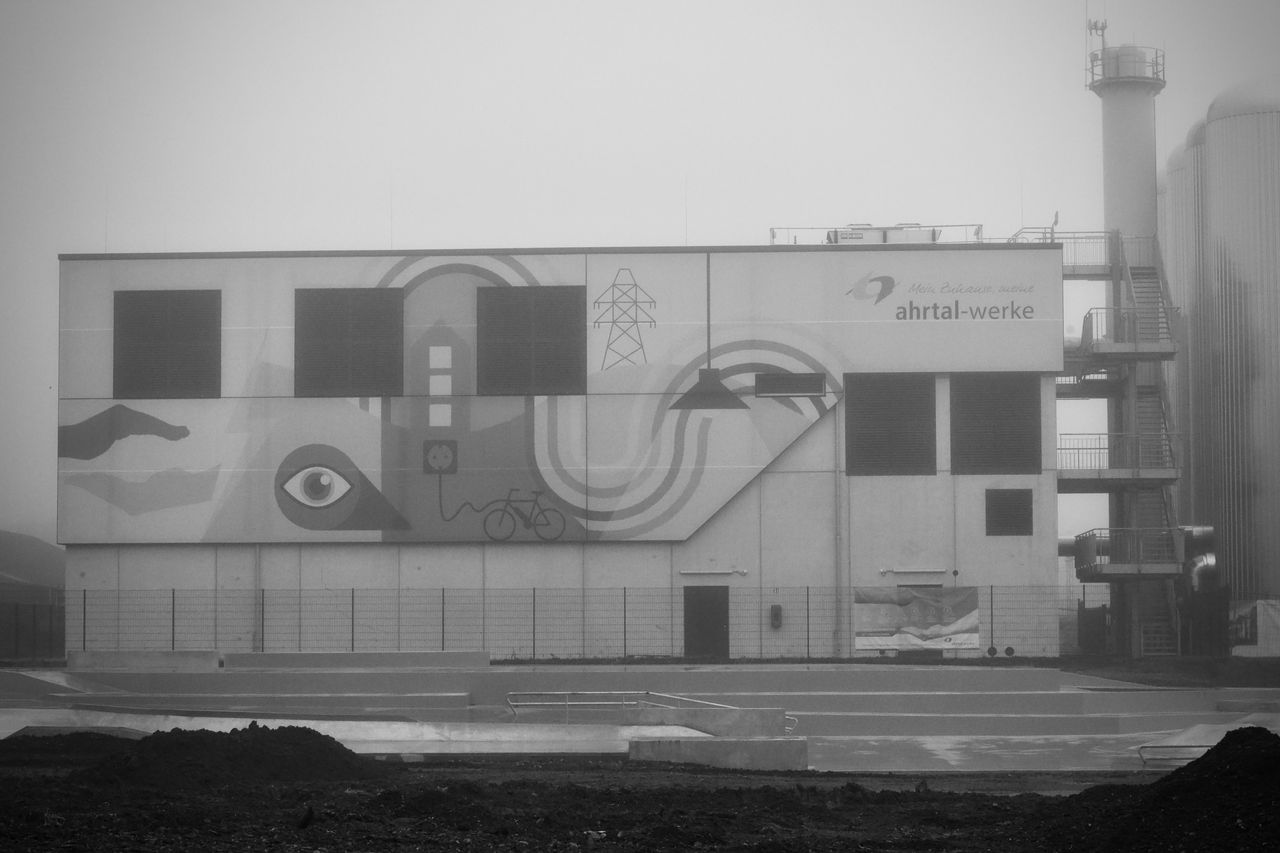 a foggy industrial building adorned with abstract graffiti and modern