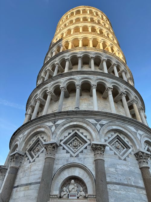 Free Iconic view of the Leaning Tower of Pisa against a clear blue sky during sunset. Stock Photo