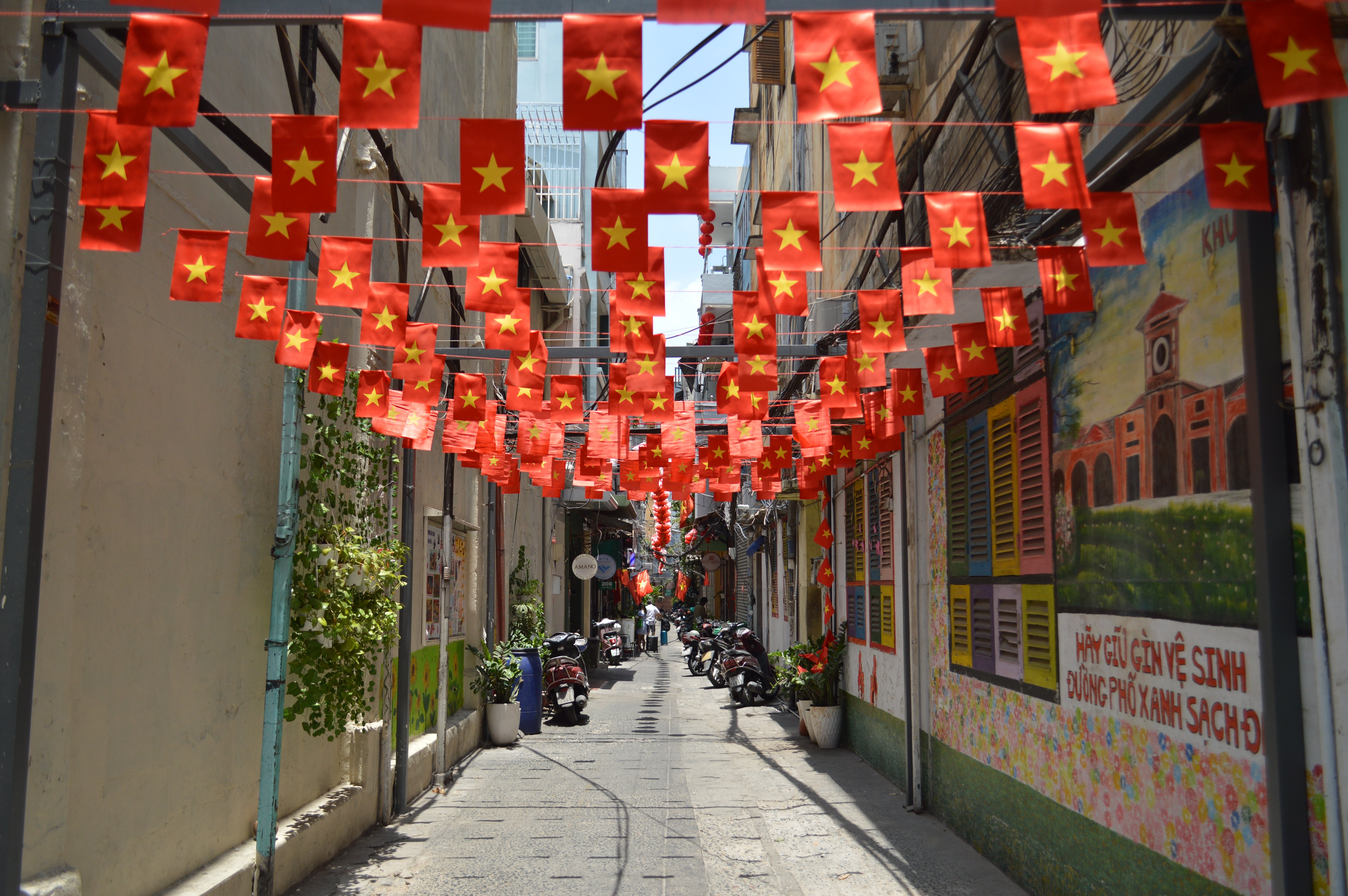 Colorful street lined with Vietnam flags under clear sky, showcasing local culture.