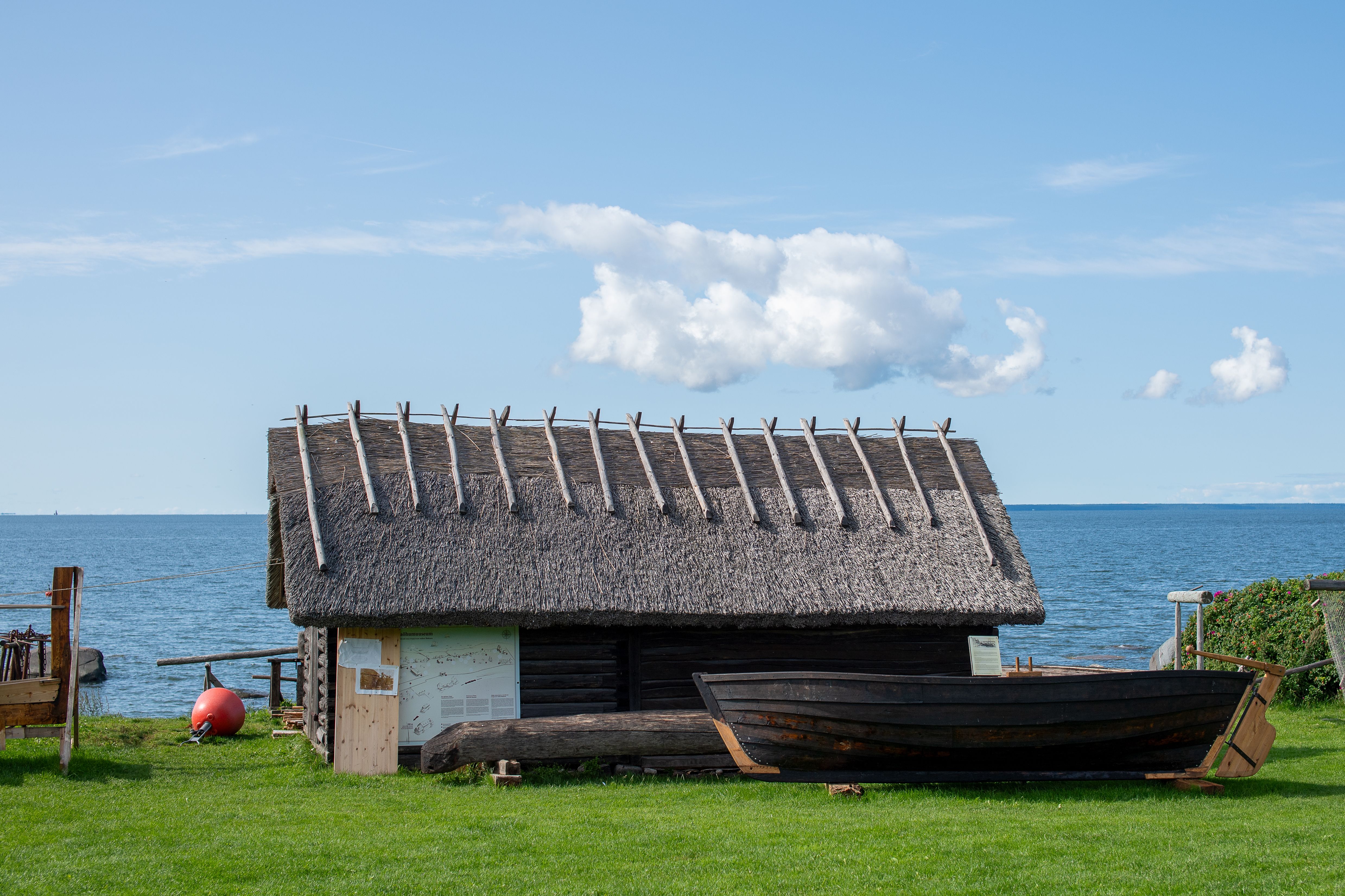 Wooden windmill and thatched farmhouses at open-air museum