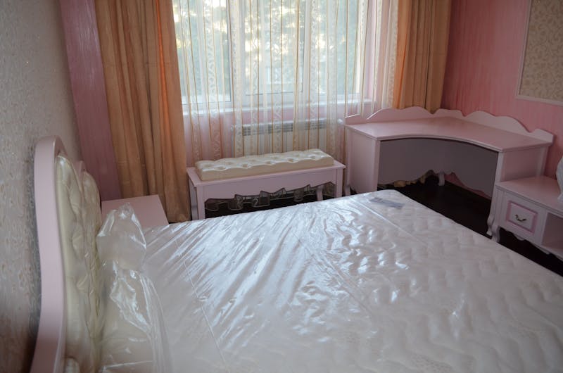 Masă de toaletă din lemn cu finisaj mat și oglindă, într-un dormitor luminos