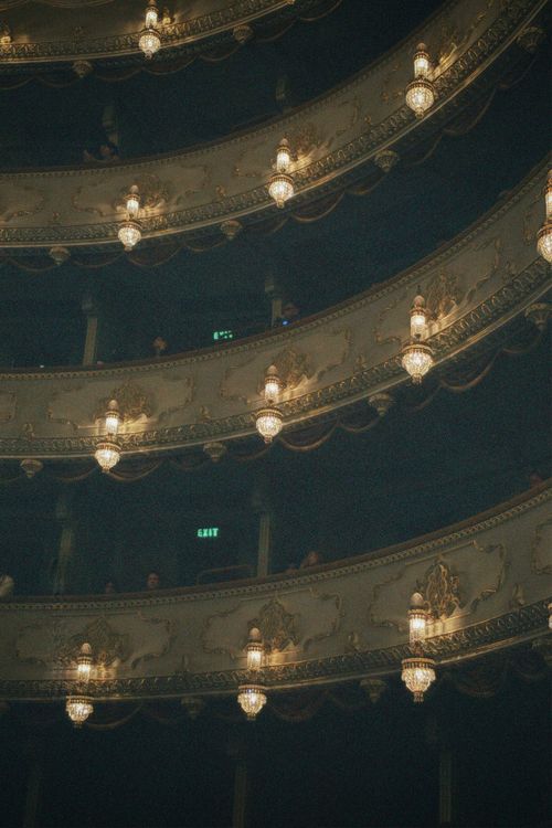 Free Elegant balconies with ornate chandeliers in a historic theater, perfect for cultural and architectural imagery. Stock Photo
