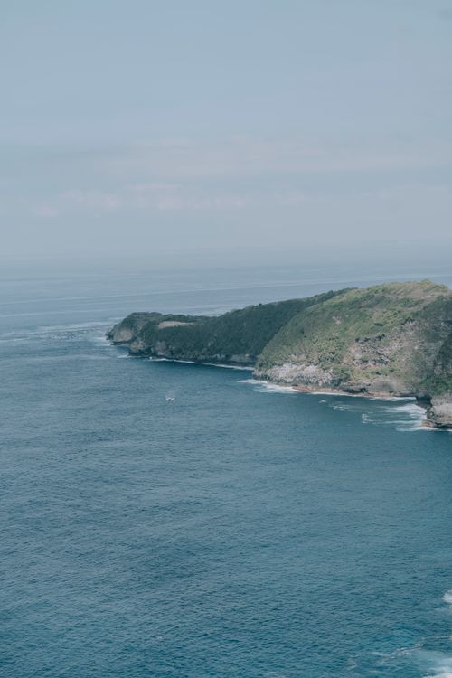Free A breathtaking view of rugged cliffs meeting the vast ocean, showcasing natural beauty. Stock Photo