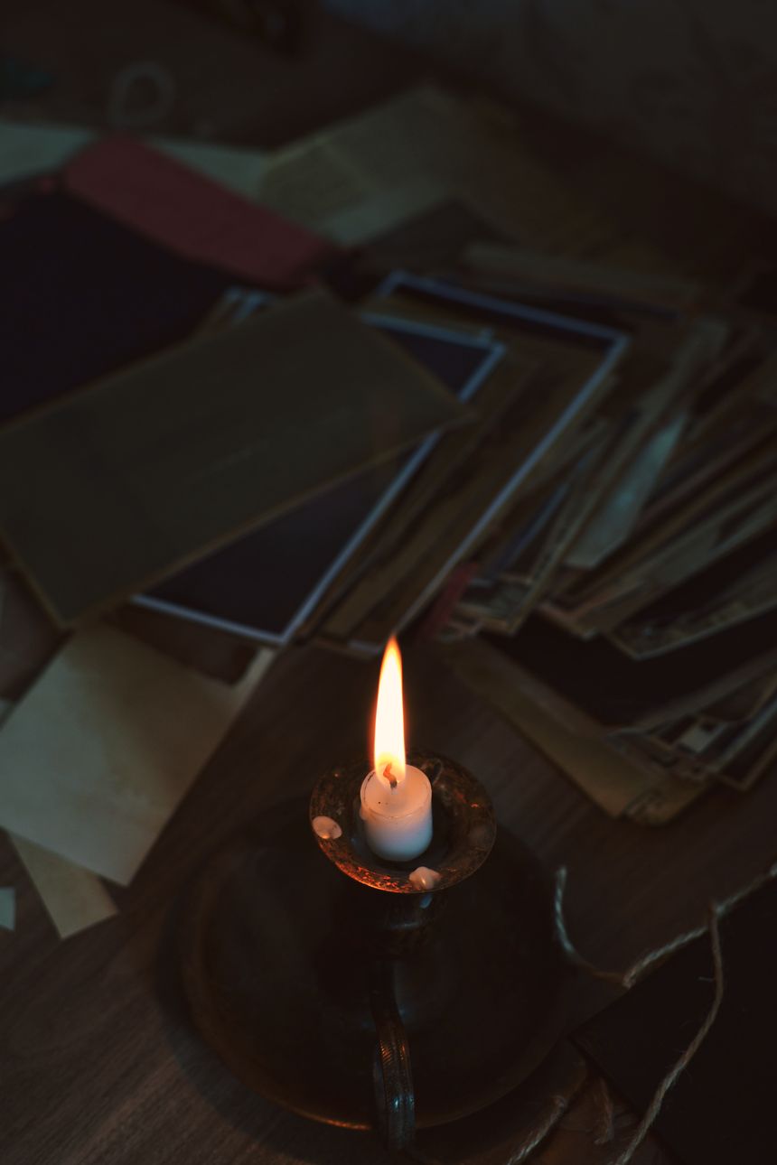 Candlelit stack of aged paper documents on a wooden table — photo by Fidan Nazim qizi on Pexels