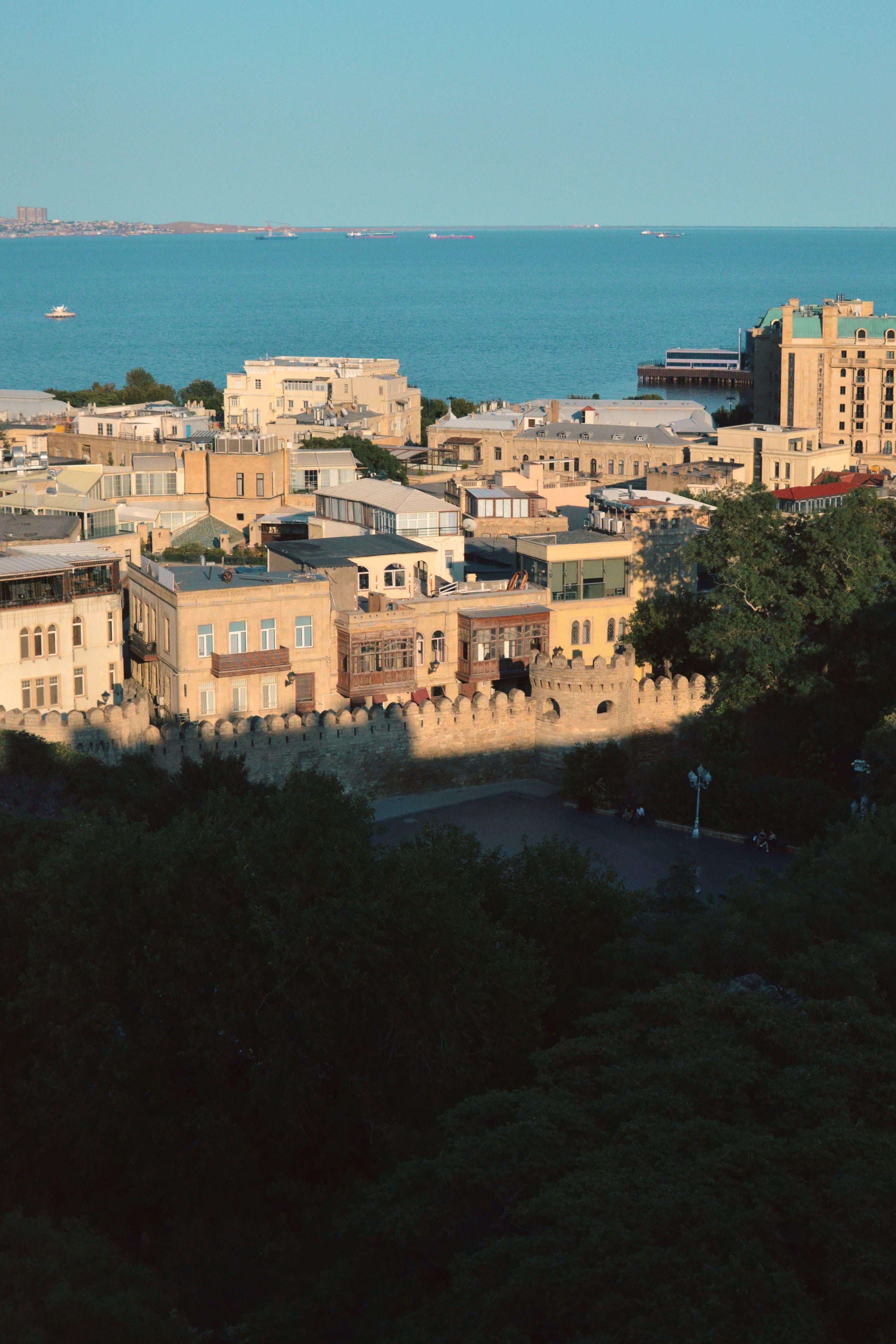A beautiful aerial view capturing Baku's historic architecture and the Caspian Sea under clear skies.
