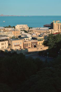 A beautiful aerial view capturing Baku's historic architecture and the Caspian Sea under clear skies.