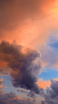 Vibrant clouds during sunset creating a stunning and dramatic sky view, showcasing a mix of orange, pink, and blue hues.
