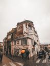 蒙马特一条下雨的巴黎街道，呈现出复古建筑和行人雨伞的迷人景象