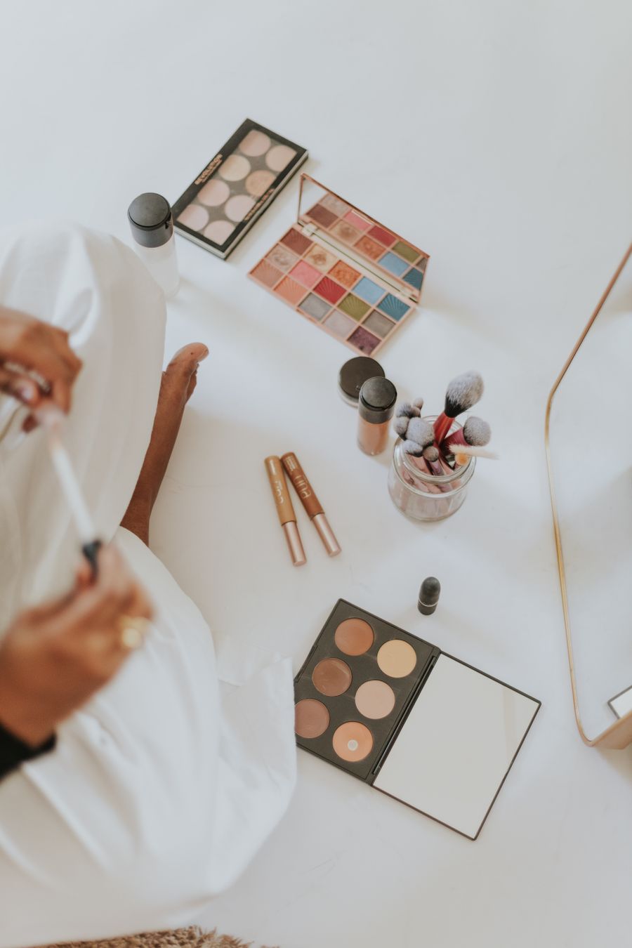 Makeup products and brushes on a bright surface