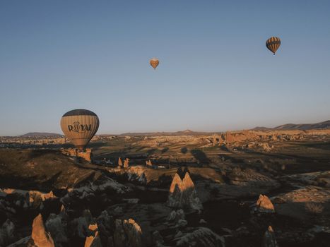 Hot air balloons soar over the unique rock formations of Cappadocia at sunrise.