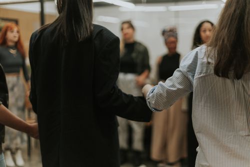 Free A diverse group of women holding hands in a circle, symbolizing unity indoors. Stock Photo