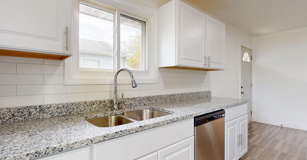 Bright modern kitchen with granite countertops and stainless steel appliances.