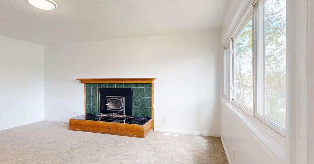 Spacious living room featuring a modern fireplace and large windows.