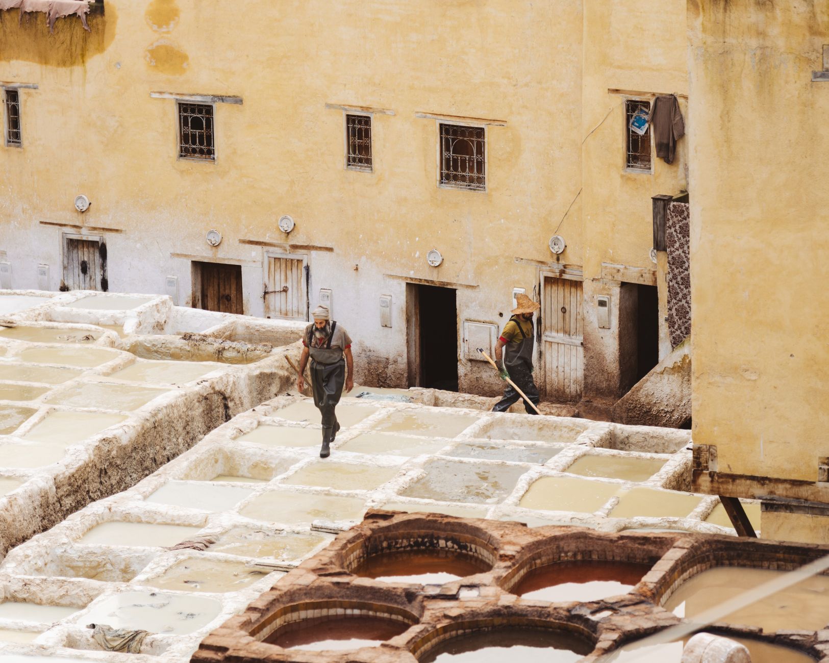 Tannery workers at a traditional site in Fez, Morocco, showcasing ancient leather processing techniques.