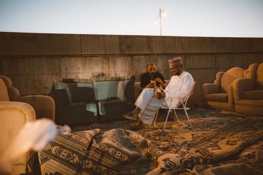 Two men enjoying a relaxed evening with traditional Omani decor in Nizwa, Oman.