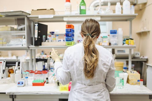 Vrouw In Witte Laboratoriumjas Met Lange Mouwen Staan