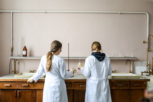 婦女在白色實驗室禮服站