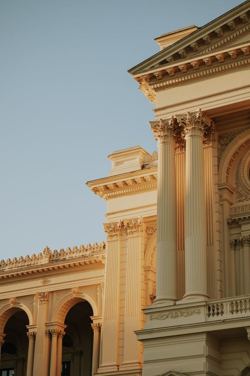 Free A close-up view of a neo-classical building facade lit by the warm glow of sunset. Stock Photo