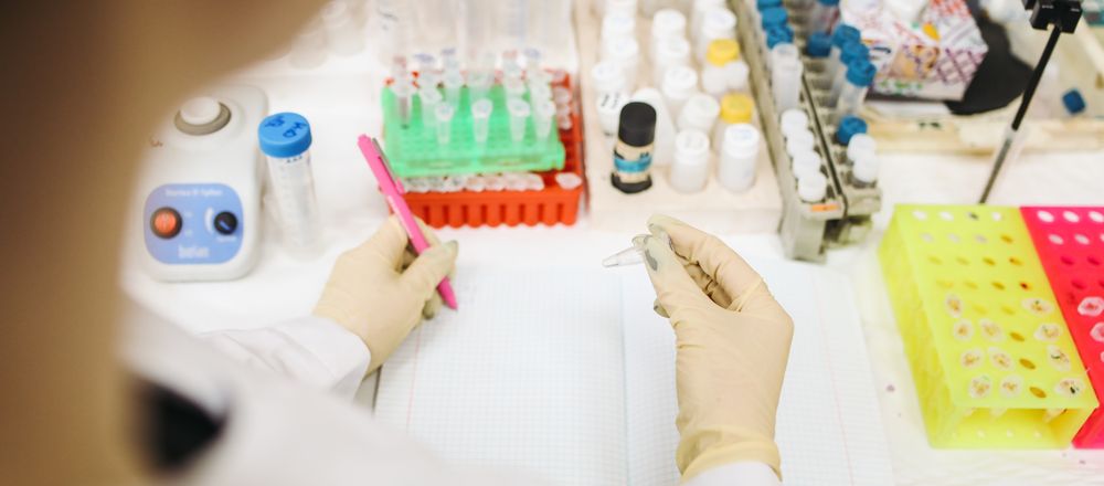 A laboratory technician analysing samples with test tubes
