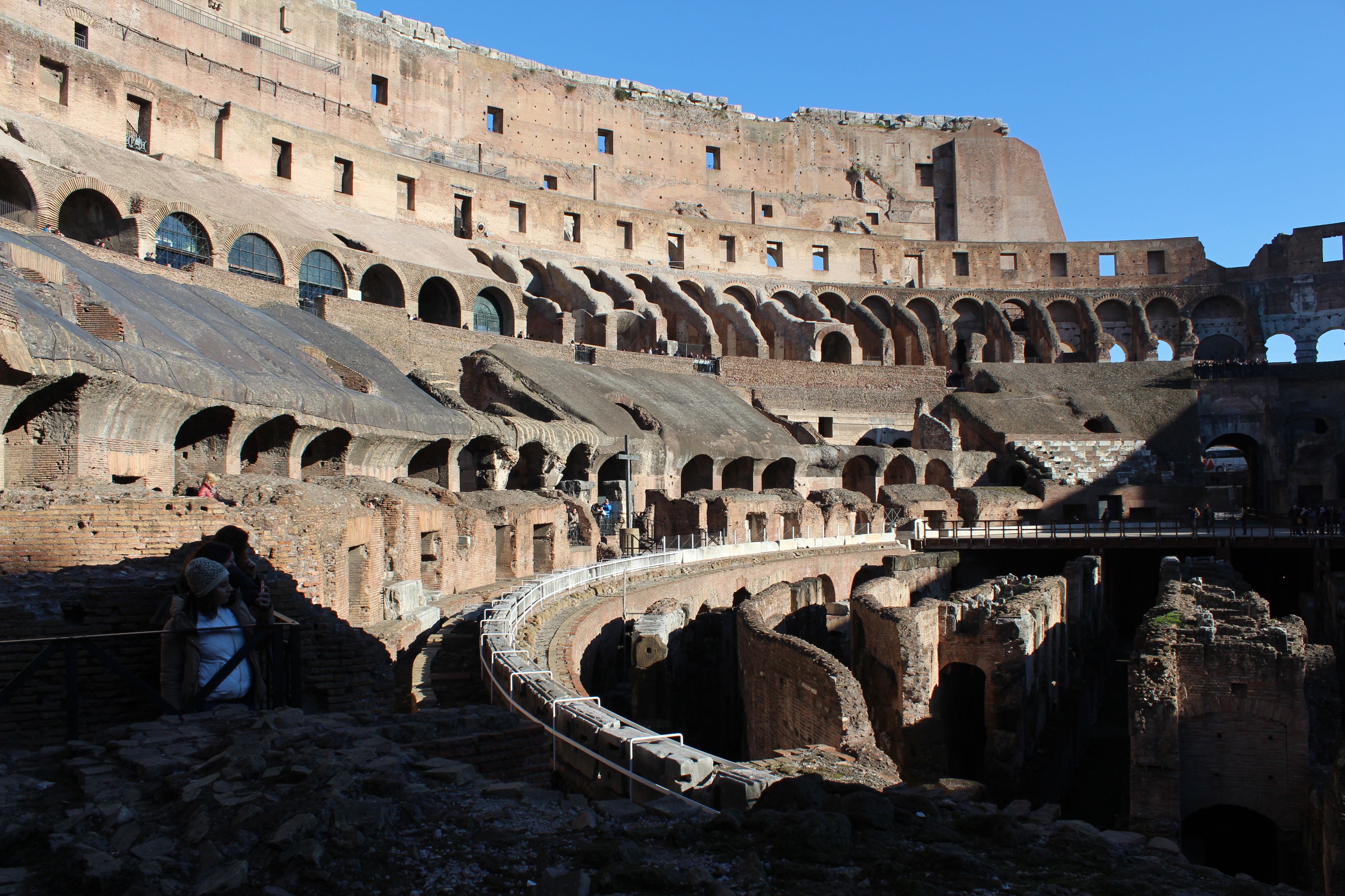 Explore the ancient architecture of the Roman Colosseum under clear skies.