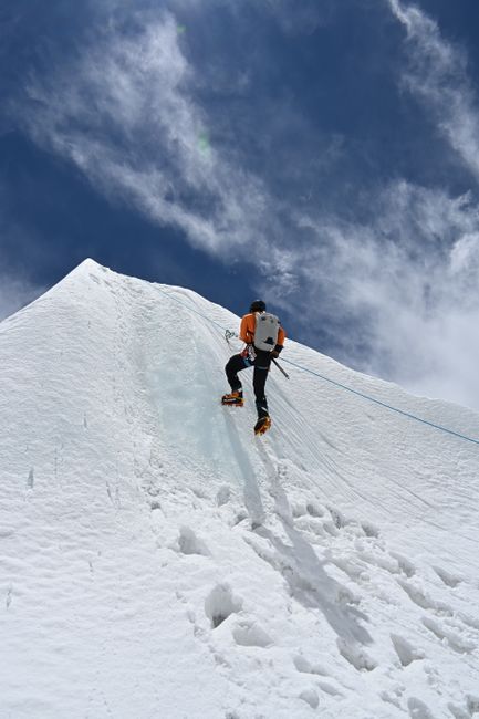 Fotomural Un escalador asciende un pico montañoso nevado en Nepal, mostrando aventura y perseverancia.