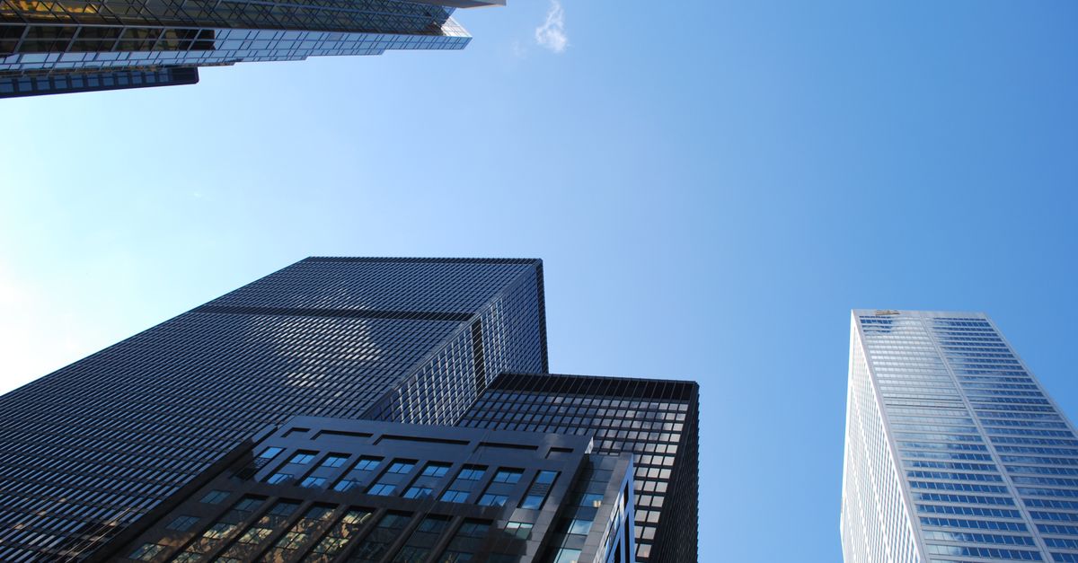 Low angle view of modern skyscrapers with a clear blue sky background.