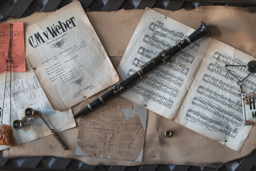Clarinete vintage de madera junto a partituras antiguas