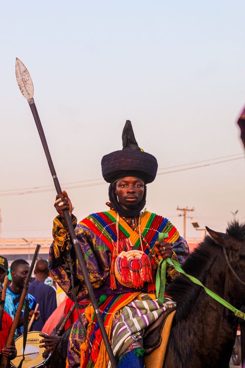Free A Nigerian horseman in vibrant attire participates in a cultural festival, showcasing traditional warrior regalia. Stock Photo