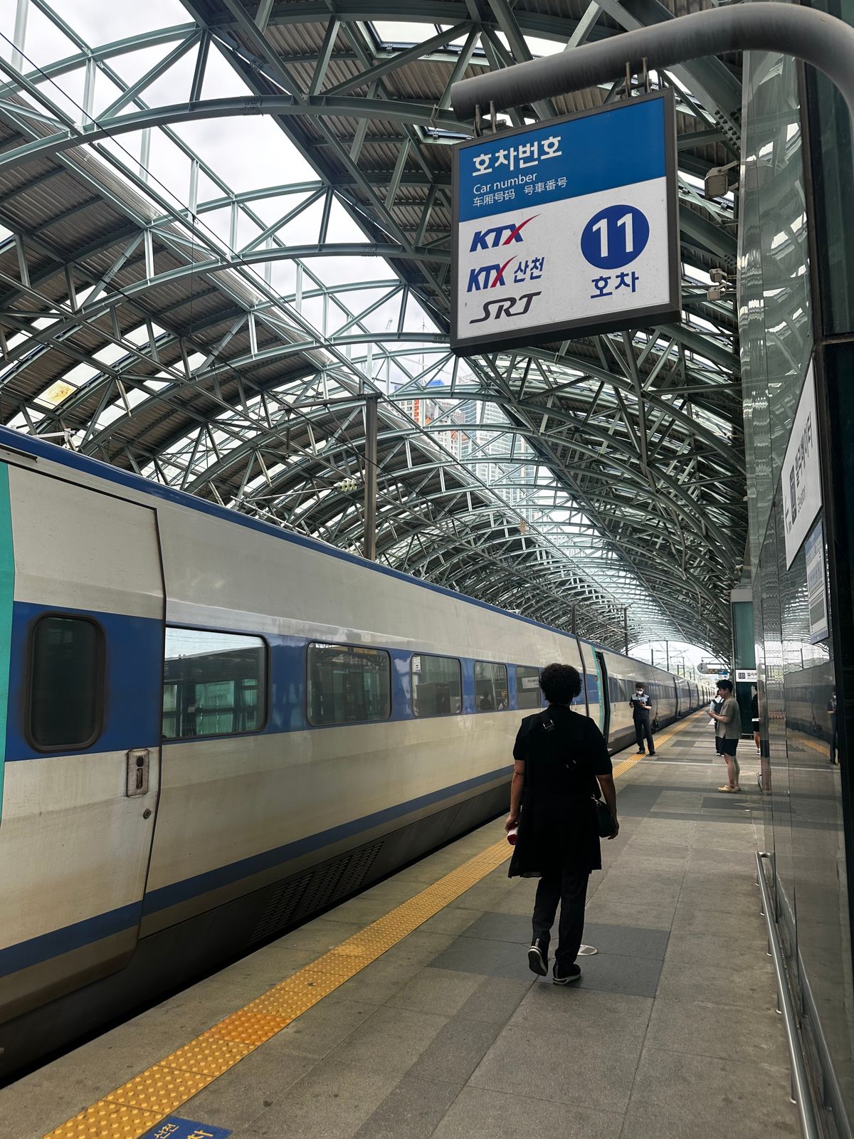 A KTX bullet train arriving at a busy South Korean station platform