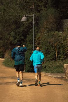 Two men enjoying a run on a scenic outdoor trail, surrounded by lush greenery and natural beauty.